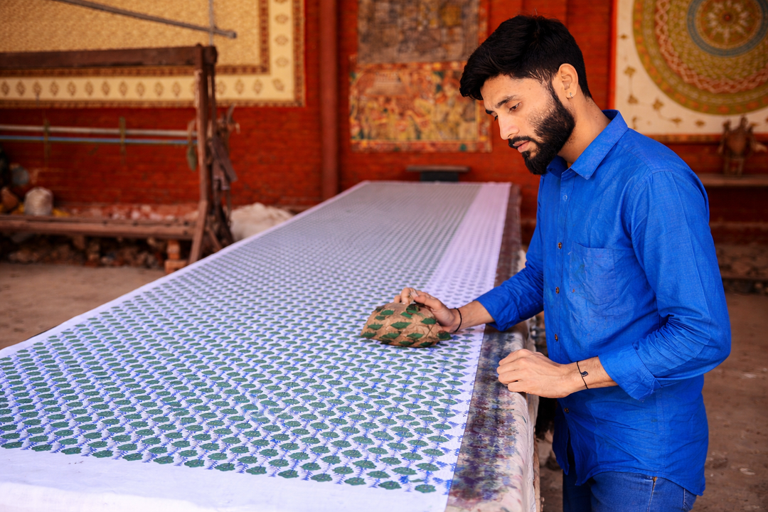 Artisan doing hand-block printing on fabric at Jaipur workshop — Nuchic